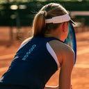 Girl on a tennis court wearing a navy sleeveless top with 'Roggio' branding.