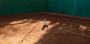 Girl sitting on a clay court for Roggio shooting.
