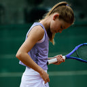 Young tennis player holding a racket on a tennis court wearing Roggio outfit