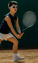 Boy playing tennis on a court with sleeveless tshirt by Roggio