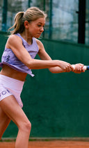 Girl playing tennis on a court wearing Roggio outfit