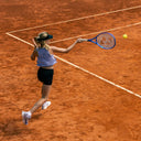 Junior tennis player in action on a clay court wearing Roggio